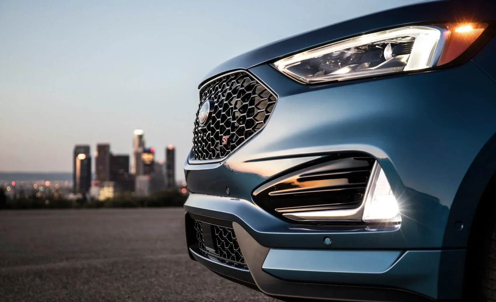 Close up of side bumper of Ford Edge with city skyline in the background from Used Car Dealer near Bloomington MN