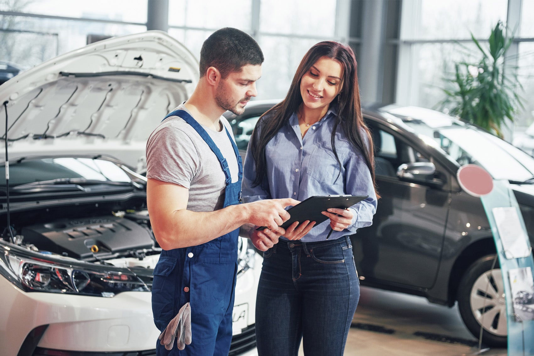 Ford Certified Technician reviewing maintenance details with customer at Service Center